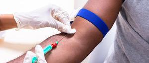 Eine Person nimmt einem Patienten Blut ab.