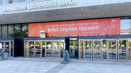 Eingang des TU Hauptgebäudes mit Aufruf, sich impfen zu lassen.
