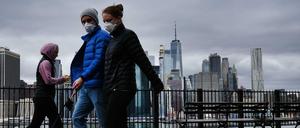 New Yorker spazieren mit Mund-Nasen-Schutz am Ufer des East River in Brooklyn (Symbolbild).