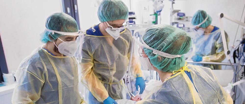 Pfleger und Pflegerinnen kümmern sich auf der Intensivstation um einen Corona-Patienten.
