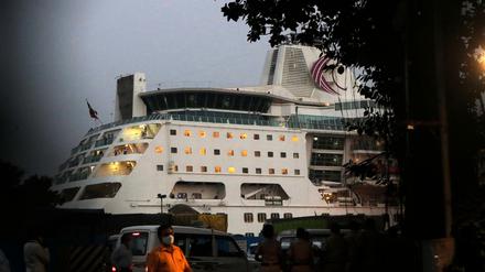 Ein Mann mit Mund-Nasen-Schutz geht an einem Kreuzfahrtschiff vorbei.