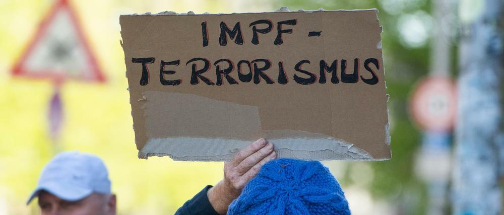 Ein Schild auf einer unerlaubten Corona-Demonstration auf dem Rosa-Luxemburg-Platz in Berlin.