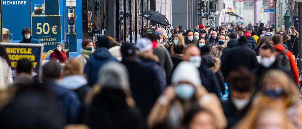 Zahlreiche Menschen mit Mund-Nasen-Schutz sind auf der Berliner Einkaufsmeile Tauentzienstraße unterwegs.