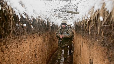 Im Mittelpunkt des Konflikts: Ein Ukrainischer Soldat patroulliert in einem Schüztengraben an der Grenze zum Territorium der von Russland unterstützten Separatisten.