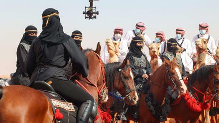 In schwarz gekleidete Frauen reiten vor den Männern auf einer Parade anlässlich der 6. Edition des „King Abdelaziz Festivals“.