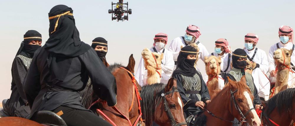 In schwarz gekleidete Frauen reiten vor den Männern auf einer Parade anlässlich der 6. Edition des „King Abdelaziz Festivals“.