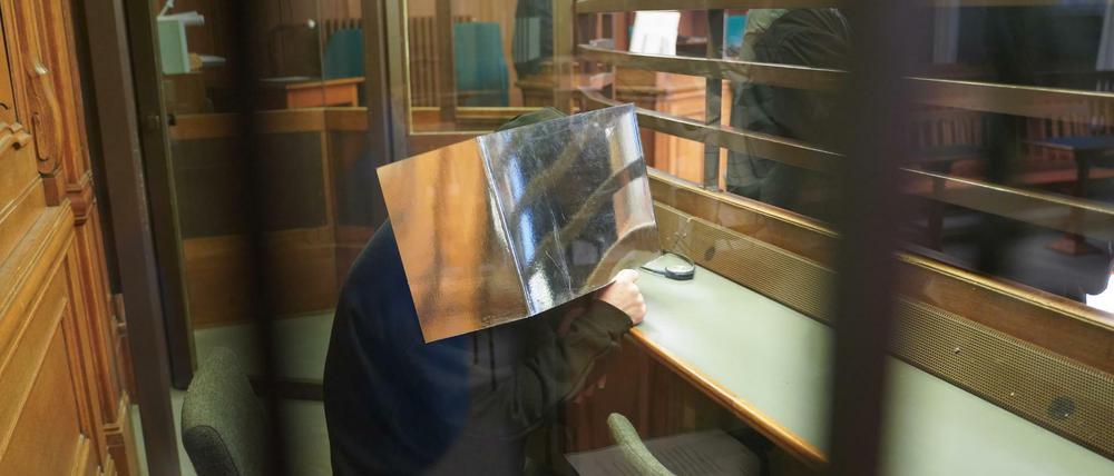 Beim Prozess-Auftakt sitzt der 54-jährige Angeklagte im Gericht in Moabit und verdeckt sein Gesicht.