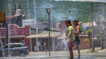 Mädchen erfrischen sich an einem Brunnen in Salta während einer heftigen Hitzewelle in Argentinien. 