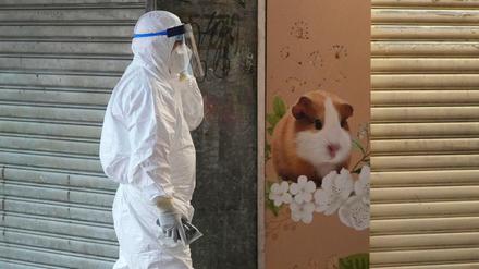 Ein Mitarbeiter des Ministeriums für Landwirtschaft, Fischerei und Naturschutz vor einer geschlossenen Tierhandlung in Hongkong.