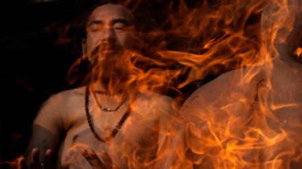 Mein Freund, das Feuer. Ein nepalesischer Gläubiger in Kathmandu hält seine Hände an ein Feuer während des Madhav-Narayan-Festes im Januar.