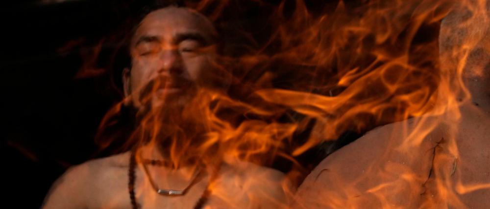 Mein Freund, das Feuer. Ein nepalesischer Gläubiger in Kathmandu hält seine Hände an ein Feuer während des Madhav-Narayan-Festes im Januar.