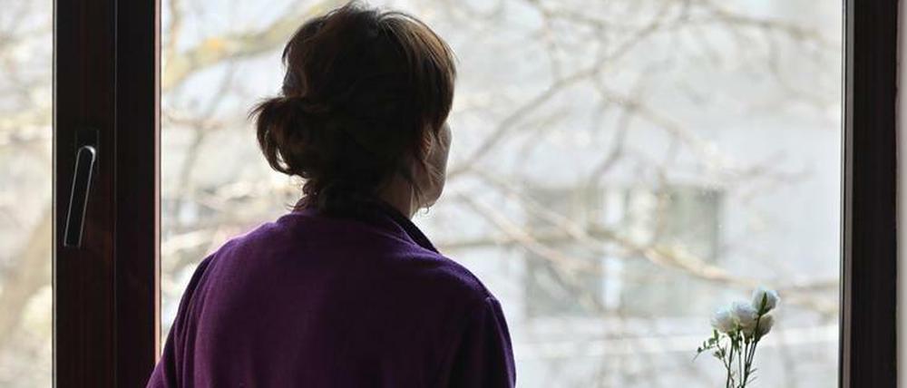 Eine Frau blickt aus dem Fenster – für viele ist das der einzige Blick nach draußen in einer Quarantäne.