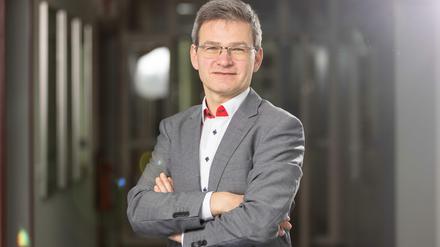 Ein querformatiges Porträtbild von Stephan Völker, mit gekreuzten Armen.