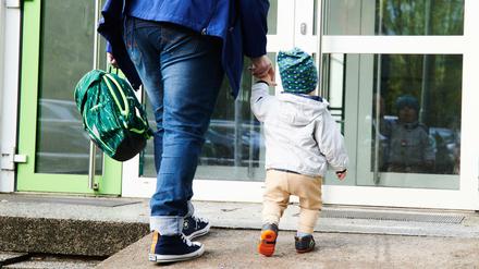 Bitte an der Tür abgeben: Eine Mutter bringt ihr Kind zur Kita.