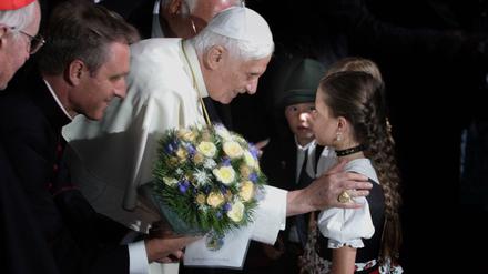 Papst Benedikt XVI zu Besuch in Bayern im Jahr 2006 mit einem Mädchen in Landestracht.