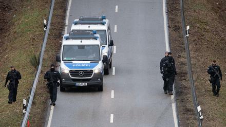 Polizeibeamte suchen nahe des Tatorts, an dem zwei Polizeibeamte durch Schüsse getötet wurden, die Straße ab.
