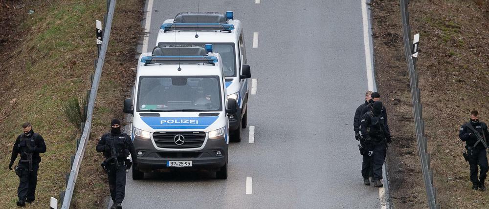 Polizeibeamte suchen nahe des Tatorts, an dem zwei Polizeibeamte durch Schüsse getötet wurden, die Straße ab.