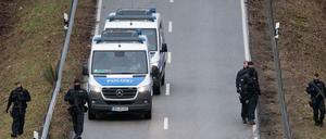 Polizeibeamte suchen nahe des Tatorts, an dem zwei Polizeibeamte durch Schüsse getötet wurden, die Straße ab.