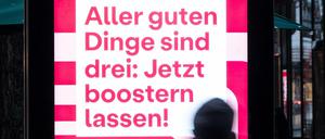 Auf einem Bildschirm wird mit dem Satz «Aller guten Dinge sind drei: Jetzt boostern lassen!» für eine dritte Impfung gegen das Coronavirus geworben.