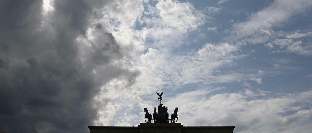 Ein graues Wolkenband zieht hinter der Silhouette der Quadriga auf dem Brandenburger Tor auf.