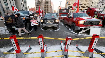 Trucks parken hinter einer Polizeiabsperrung in Ottawa.