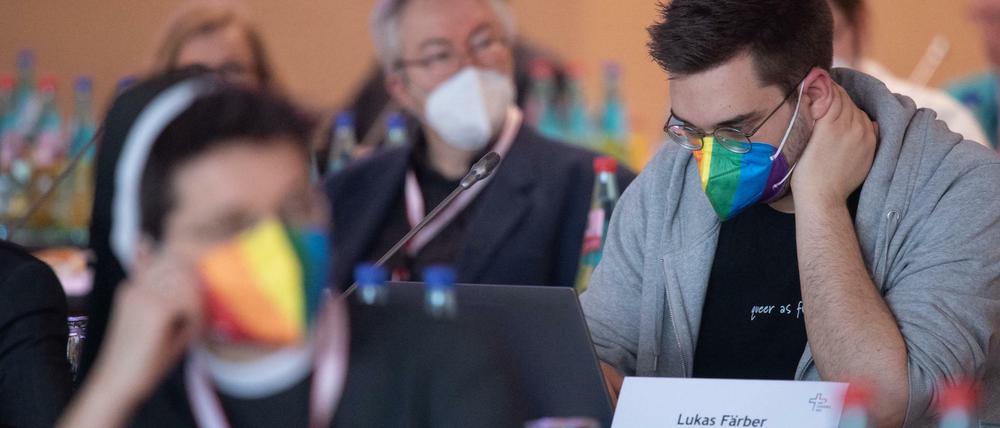 Eine Teilnehmerin und ein Teilnehmer mit Regenbogen-Maske bei der Dritten Synodalversammlung der deutschen Katholiken