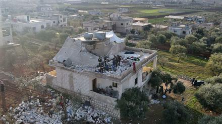 Menschen versammeln sich nach dem US-Angriff in einer syrischen Stadt an einem zerstörten Haus.