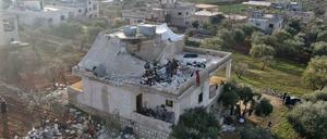 Menschen versammeln sich nach dem US-Angriff in einer syrischen Stadt an einem zerstörten Haus.