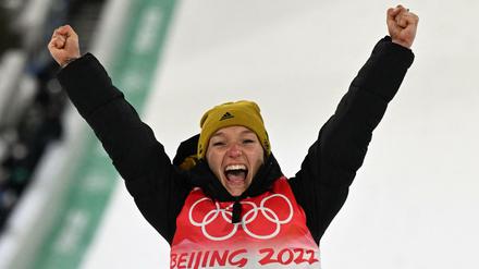 Skispringerin Katharina Althaus gewinnt die erste Medaille für Deutschland und jubelt bei der Siegerehrung über ihren zweiten Platz.