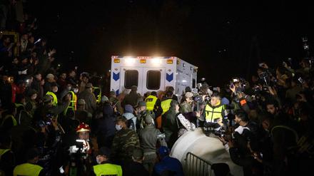 Schaulustige schauen dem Krankenwagen hinterher.