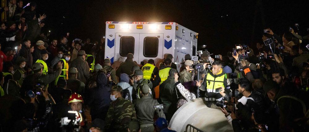Schaulustige schauen dem Krankenwagen hinterher.