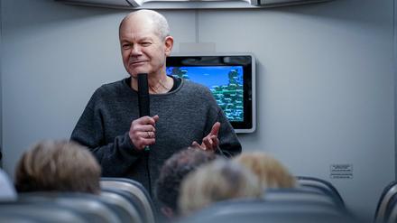 Im Regierungsflieger zeigt sich Bundeskanzler Olaf Scholz (SPD) betont entspannt.