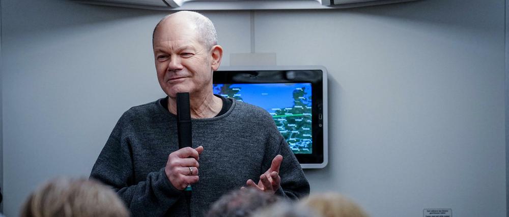 Im Regierungsflieger zeigt sich Bundeskanzler Olaf Scholz (SPD) betont entspannt.