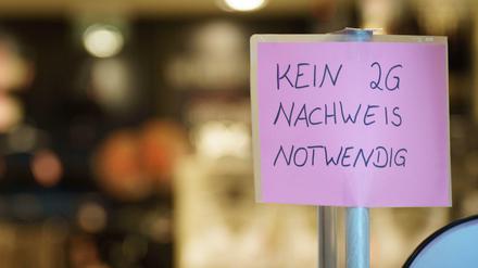 Ein Schild mit der Aufschrift "Kein 2G-Nachweis notwendig" steht am Eingang zu einem Geschäft.