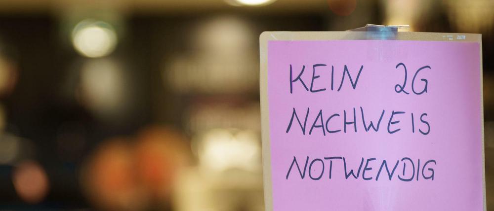 Ein Schild mit der Aufschrift "Kein 2G-Nachweis notwendig" steht am Eingang zu einem Geschäft.