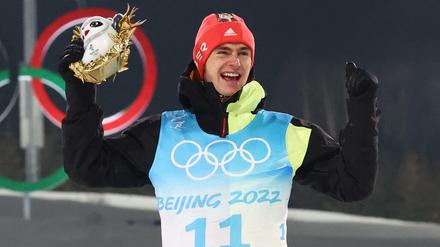 Der nordische Kombinierer Vinzenz Geiger ist neuer Olympiasieger und jubelt bei der Siegerehrung.