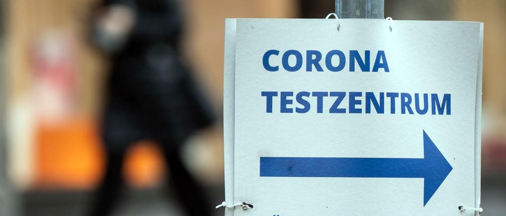 Ein Pappschild weist die Richtung zu einem Corona-Testzentrum.