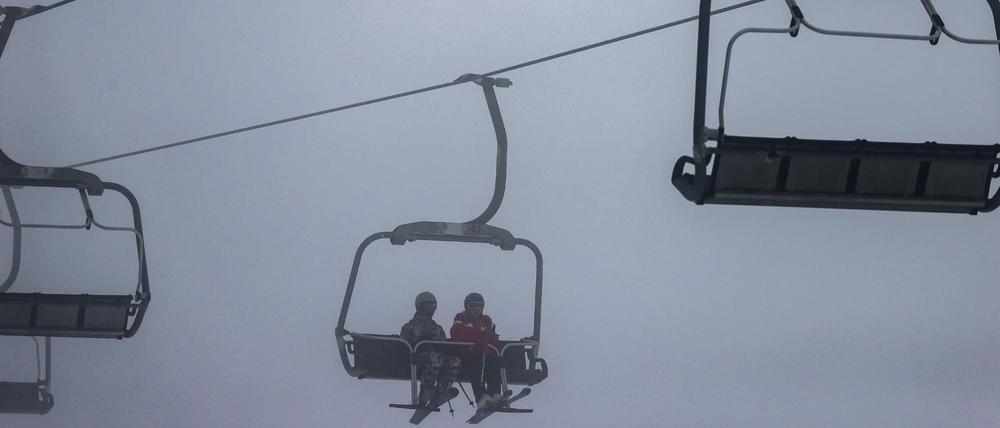 Sachsen, Schöneck: Wintersportler sitzen bei trüber Sicht auf einem Sessellift im Vogtland (Symbolbild). 