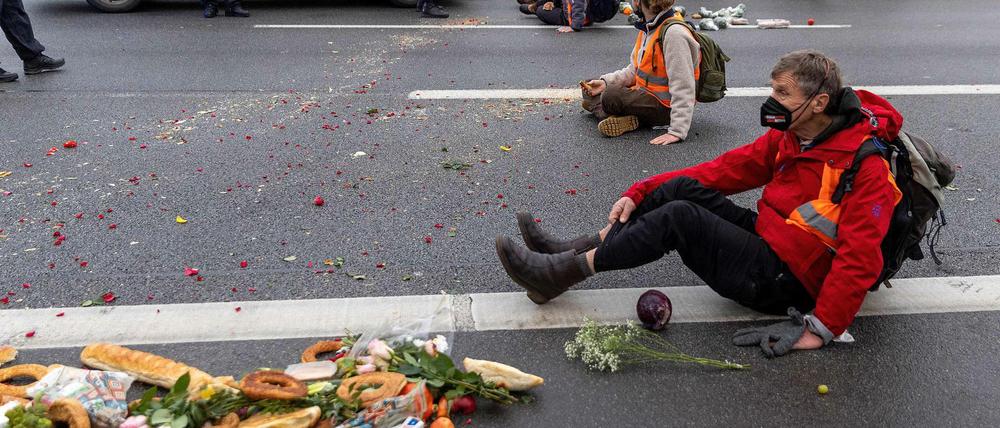 Klimaaktivisten blockieren die Fahrbahn der A100 in Berlin, um gegen Lebensmittelverschwendung zu protestieren. 