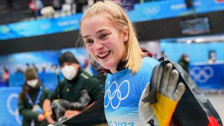 Hannah Neise feiert ihren Olympiasieg im Skeleton mit der deutschen Fahne.