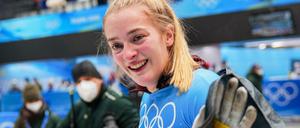 Hannah Neise feiert ihren Olympiasieg im Skeleton mit der deutschen Fahne.