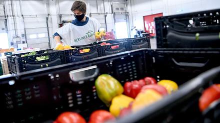 Eine Helferin der Berliner Tafel packt Lebensmittel in Tafel-Tüten.