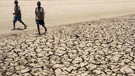 Zwei Jungen vom Volk der Turkana laufen über ausgetrockneten Boden in der Nähe ihres Dorfes Gakong in Kenia. 