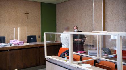 Ein Polizist (links), der wegen unerlaubten Erwerbs und Besitzes von Betäubungs- und Dopingmitteln angeklagt ist, steht vor Prozessbeginn mit seinem Anwalt im Verhandlungssaal.