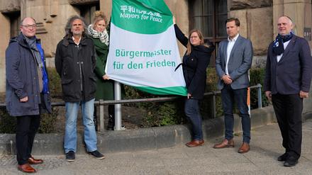 Bürgermeisterin Kirstin Bauch und die Stadträt:innen Arne Herz, Oliver Schruoffeneger, Heike Schmitt-Schmelz, Fabian Schmitz-Grethlein und Detlef Wagner hissen "Mayors for Peace"-Flagge.