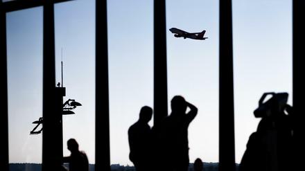 Besucher schauen sich am Hauptstadtflughafen BER den Start eines Flugzeugs an.