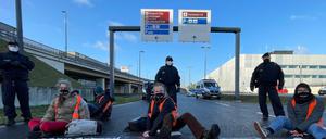 Klimaschutz-Aktivisten der Initiative "Aufstand der letzten Generation" blockieren eine Zufahrt zum Hauptstadt-Flughafen BER.