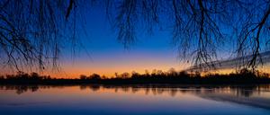 Kurz vor Sonnenaufgang leuchtet der Morgenhimmel farbenprächtig über dem deutsch-polnischen Grenzfluss Oder.