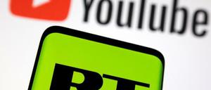 Das Logo des russischen Senders „Russia Today“ (RT) ist vor dem Logo der Streaming-Plattform Youtube zu sehen.