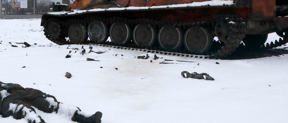 Die Leiche eines Soldaten liegt schneebedeckt neben einem Militärfahrzeug in Charkiw. 
